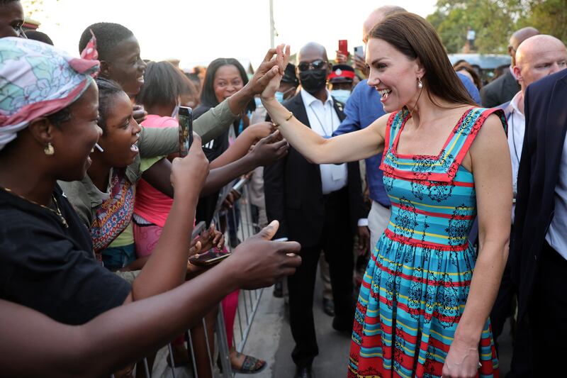 Kate shake hands with locals in Trench Town, Jamaica.