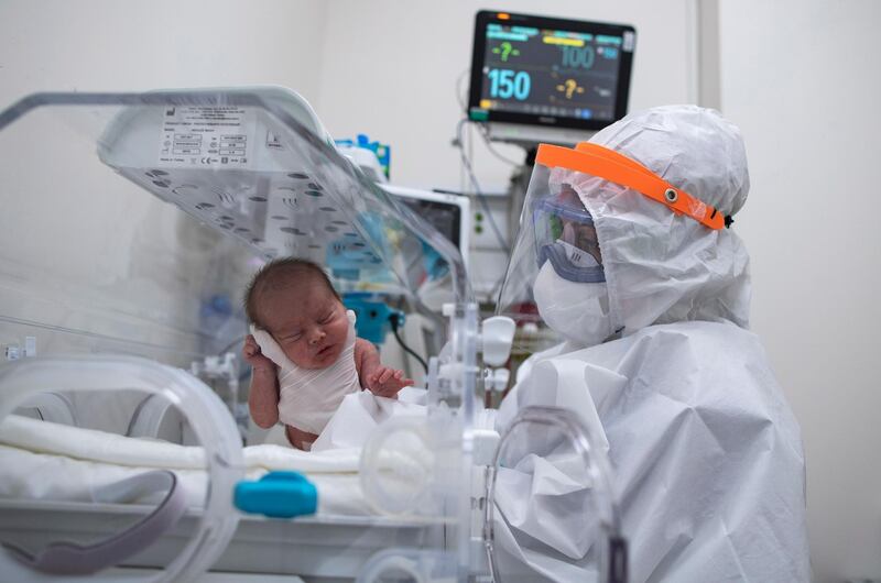 A medical worker wearing personal protective equipment attends to a newborn child of a woman with Covid-19 at the Sancaktepe Martyr Prof Dr Ilhan Varank Training and Research Hospital in Istanbul, Turkey, EPA