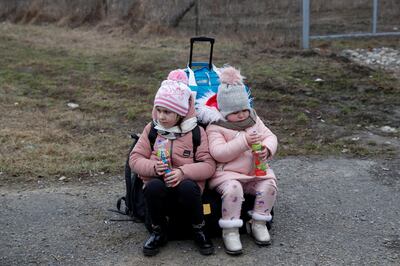 Children fleeing from Ukraine embrace arrive in Hungary, after Russia launched a massive military operation against Ukraine, at a border crossing in Beregsurany, Hungary, February 26, 2022.  REUTERS / Bernadett Szabo