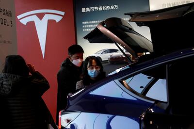 Visitors check a China-made Tesla Model Y sport utility vehicle at the company's showroom in Beijing. Reuters