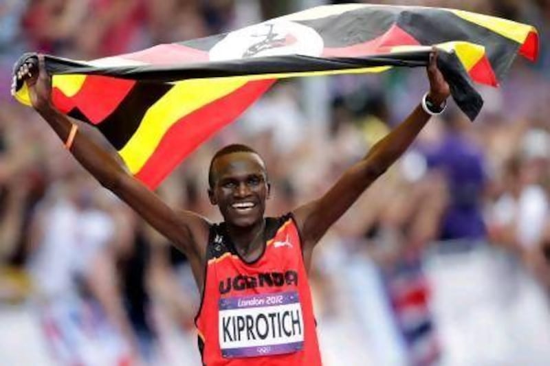 Uganda's Stephen Kiprotich celebrates with his national flag after winning the men's marathon in two hours, 08.01 seconds.