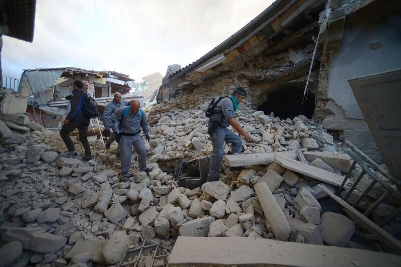 Rescuers search for victims in damaged buildings after a strong heartquake hit Amatrice. Deaths were reported in three villages in a mountainous area straddling the regions of Lazio and Marche: Amatrice, Accumoli and Pescara del Tronto. Filippo Monteforte / AFP