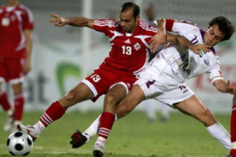 Al Ain's Jorge Valdivia, right, attempts to tackle Al Sharjah's Salem Mohammad