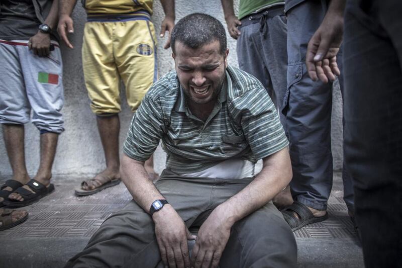 A Palestinian man cries surrounded by relatives after he saw the dead bodies of two of his sons in the morgue of the Shifa hospital in Gaza, 17 July 2014. Three young kids of the Shaibar family, two brothers and their female cousin, lost their lives by shell fire from Israeli Defence Forces airstrike in Gaza City when the five-hour ceasefire came to an end. Oliver Weiken/EPA