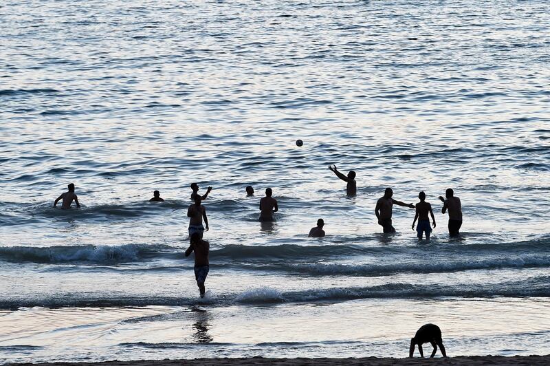 People play a ball as they enjoy a bath in the sea during a hot evening on a public beach at Ramlet Al Bayda seaside in Beirut, Lebanon.  EPA