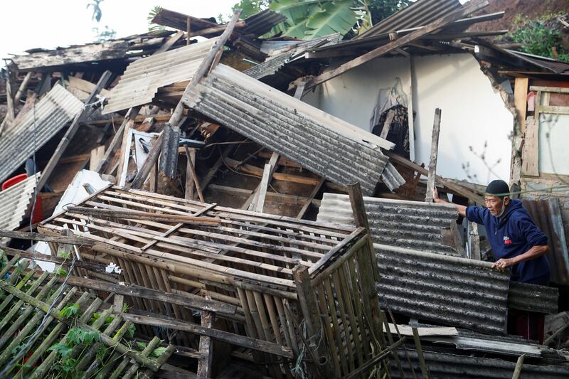 An elderly man stands near his damaged house in Cugenang, Cianjur. Reuters