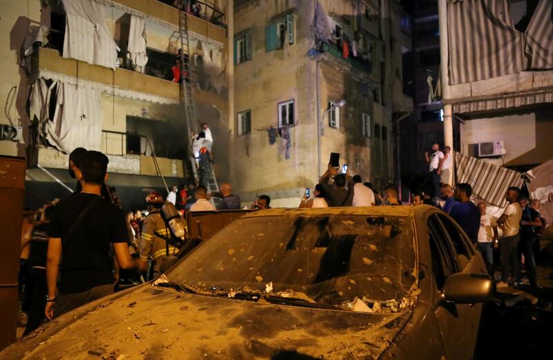 People gather as rescuers evacuate people from their buildings after a fuel tank exploded in the al-Tariq al-Jadida neighborhood of Beirut, Lebanon. REUTERS