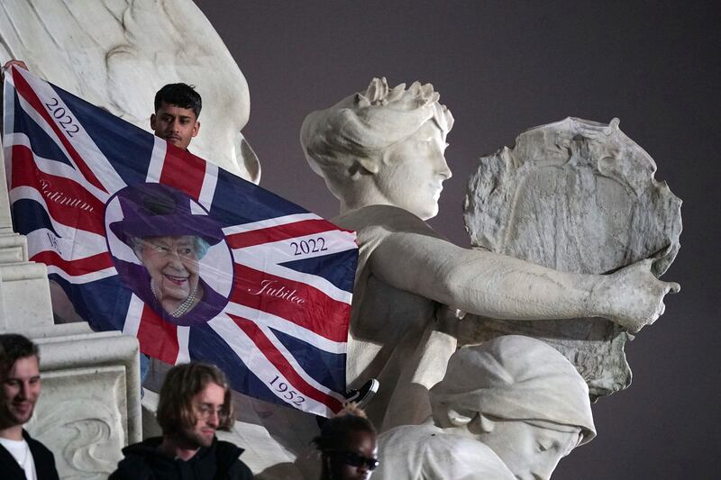 Mourners on the Queen Victoria Memorial outside Buckingham Palace. PA