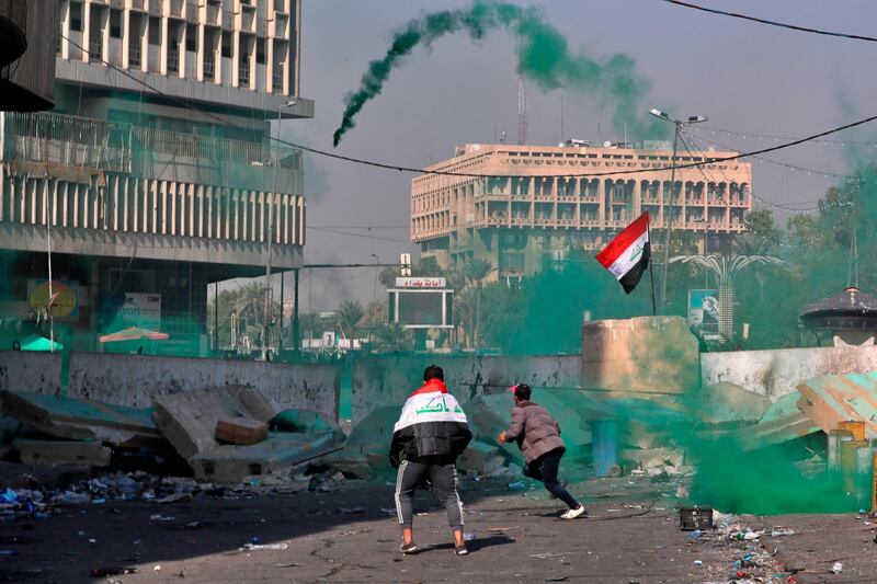 Riot police fire tear gas and smoke bombs during clashes between Iraqi security forces and anti-government protesters in Baghdad, Iraq. AP Photo