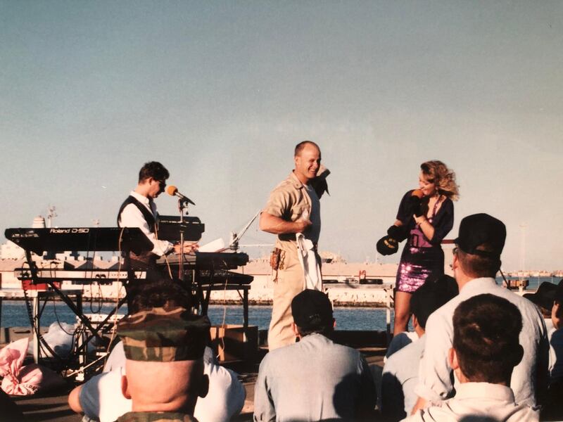 Musicians Michelle Brown and Mark Lloyd give away a free T-shirt as they perform a two-hour concert in Dubai for the US military on the USS Portland, January, 1991. The ship was docked close to Port Rashid. Courtesy: Michelle Brown