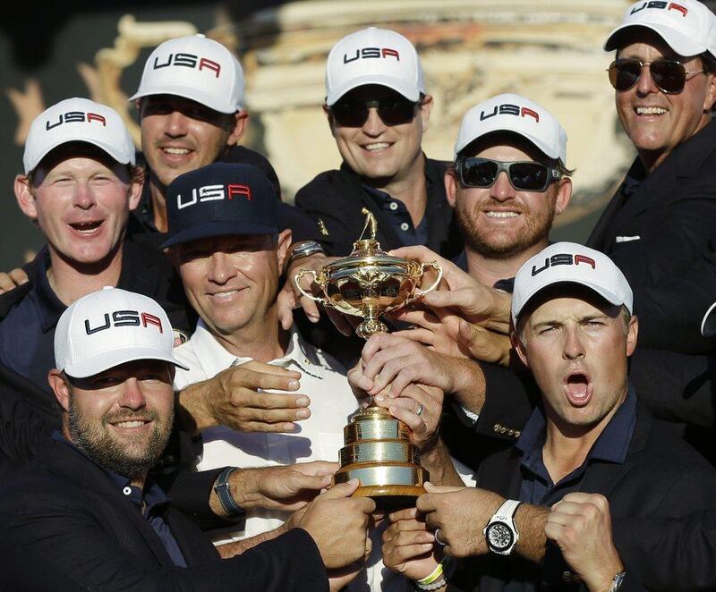 United States captain Davis Love III is surrounded by his players as they pose for a picture during the closing ceremony of the Ryder Cup. David J. Phillip / AP