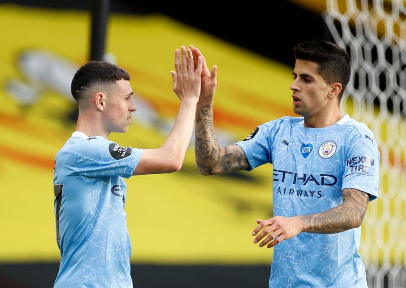 Manchester City's Phil Foden, left, celebrates with Manchester City's Joao Cancelo after scoring his side's third goal. AP