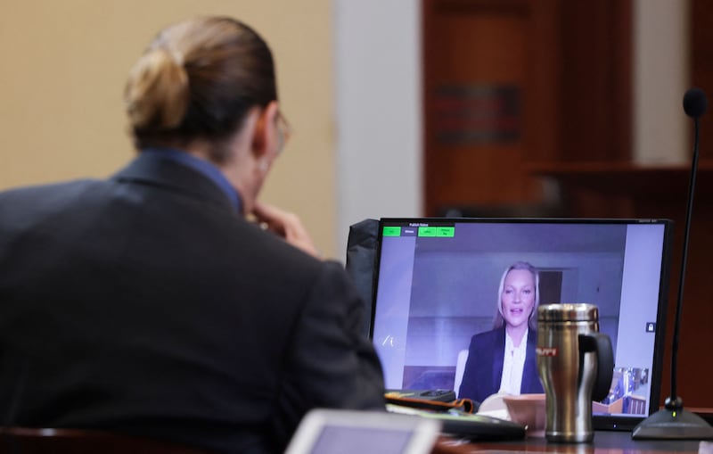Depp listens as his former girlfriend Kate Moss gives evidence via video link. AFP