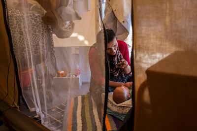 A young Afghan asylum seeker, a new mother, cares for her baby, who was born a few months after she and her husband arrived at the Oinofyta camp on the outskirts of Athens, Greece. Fahrinisa Campana for The National