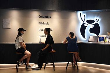 People chat in a Luckin Coffee outlet in Beijing. Since reaching a high of $50 per share in January, the coffee chain has cratered more than 90% in Nasdaq trading. AFP