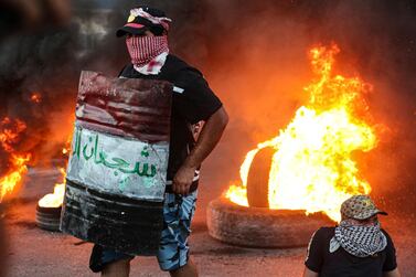 Protesters set tyres on fire during an anti-government protest outside the provincial council building in Basra, Iraq, on Monday, August 17, 2020. AP