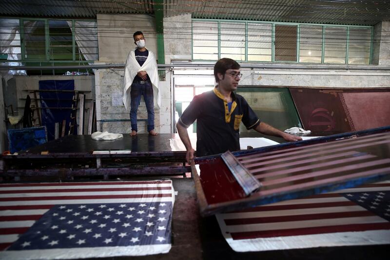 Iranian workers collect altered Israeli flags at a large factory that males US and Israeli flags for Iranian protesters to burn in Khomein City. West Asia News Agency via Reuters