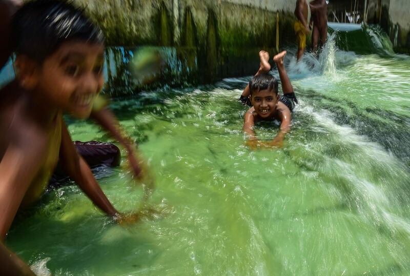 Bangladeshi children splash around in a pool in Dhaka. Munir Uz Zaman / AFP Photo