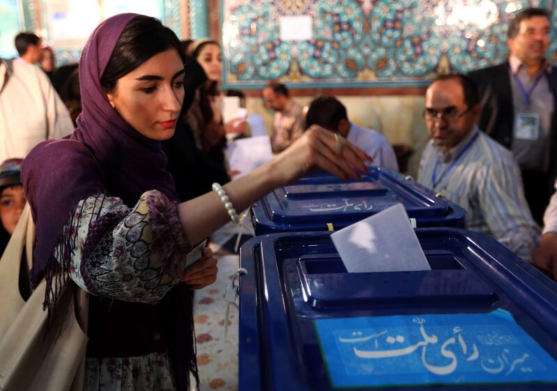An Iranian woman casts her vote in the first round of the presidential election at a polling station in Tehran on June 14, 2013. Iranians are voting to choose a new president in an election the reformists hope their sole candidate will win in the face of divided conservative ranks, four years after the disputed re-election of Mahmoud Ahmadinejad. AFP PHOTO/ATTA ATTA KENARE
 *** Local Caption ***  340797-01-08.jpg