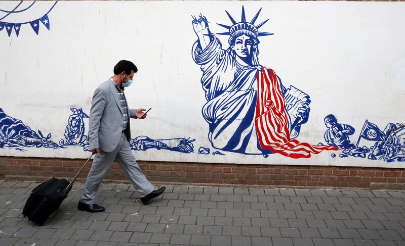 An Iranian walks past a mural depicting a defaced Statue of Liberty on the wall of the former US embassy in Tehran, Iran, in December 2021. EPA