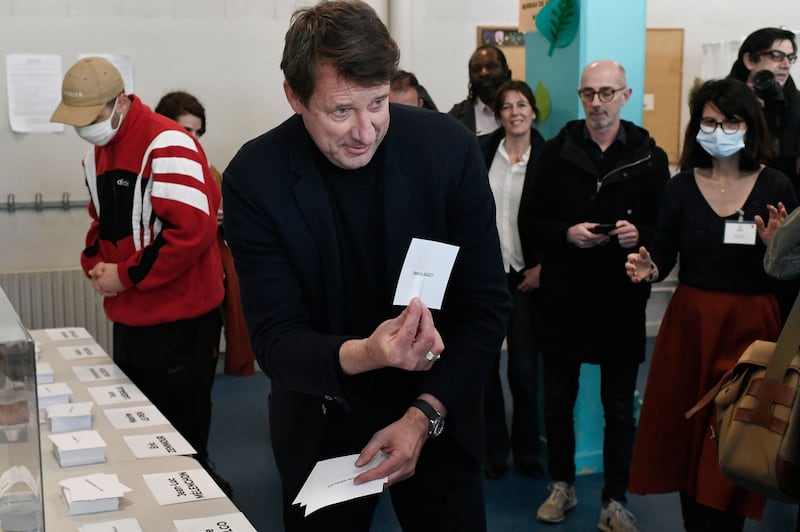 The French ecologist party EELV's presidential candidate, Yannick Jadot, takes ballots before voting at a polling station in Paris. AFP