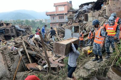 People carry their belongings amidst the rubble of collapsed houses in Bhaktapur, on the outskirts of Kathmandu, on April 27, 2015, two days after a 7.8 magnitude earthquake hit Nepal. Nepalis started fleeing their devastated capital on April 27 after an earthquake killed more than 3,800 people and toppled entire streets, as the United Nations prepared a "massive" aid operation.  AFP PHOTO / PRAKASH MATHEMA / AFP PHOTO / PRAKASH MATHEMA