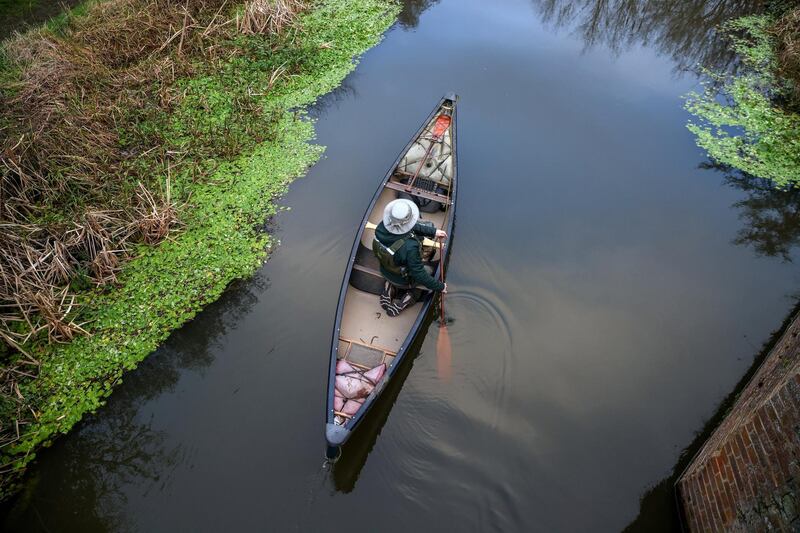 A man paddles a canoe on the River Wey near Ripley in the county of Surrey, Britain. Reuters
