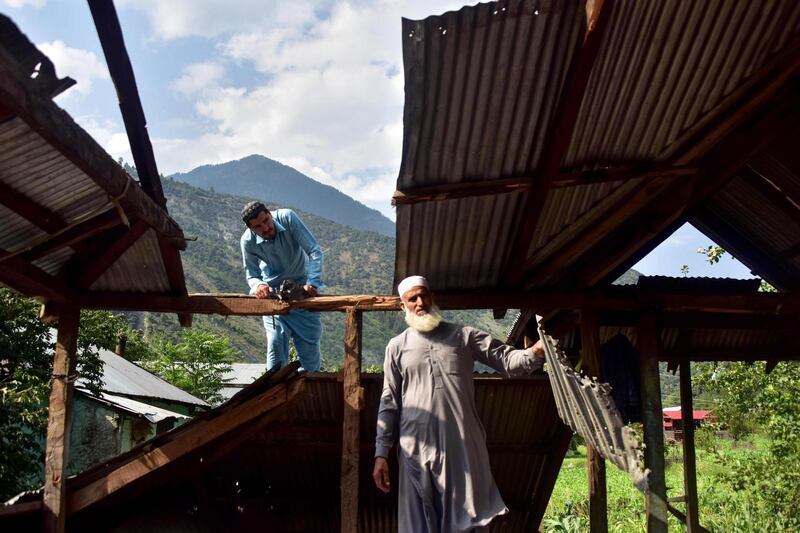 Kashmiri men look at a damaged part of their house following recently cross border shelling at the Line of Control, the de facto border between Pakistan and India, in Neelum Valley of Pakistan-administered Kashmir. AFP