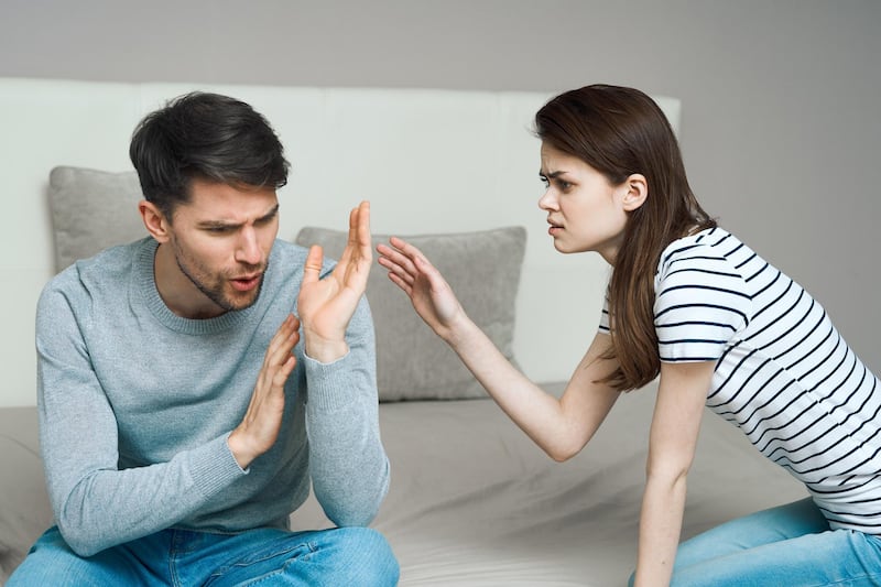 A young couple of man and woman swear at home.