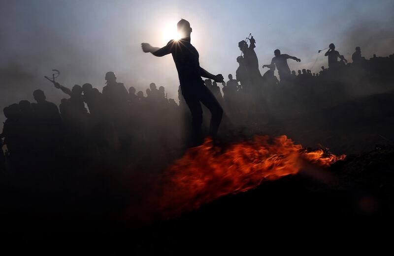 Palestinian demonstrators hurl stones at Israeli troops during a protest in the southern Gaza Strip. Reuters