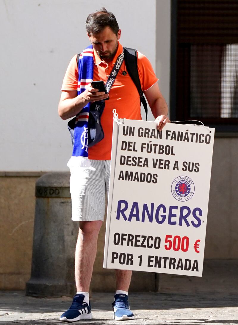 A Rangers fan in Seville holds a sign asking for a ticket to the match. PA