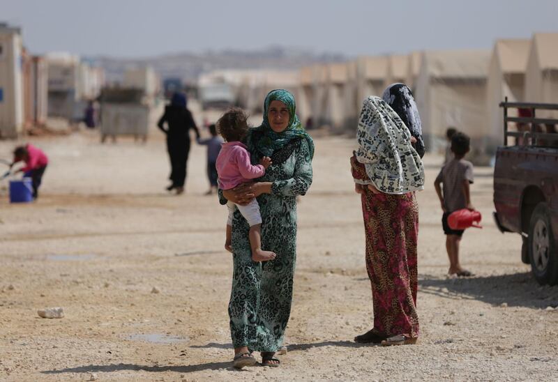 People who fled Syria's Idlib province are pictured at a camp in Kafr Lusin near the border with Turkey in the northern part of the province. AFP