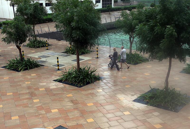 People enjoy the rainy weather at Jumeirah Lakes Towers in Dubai.