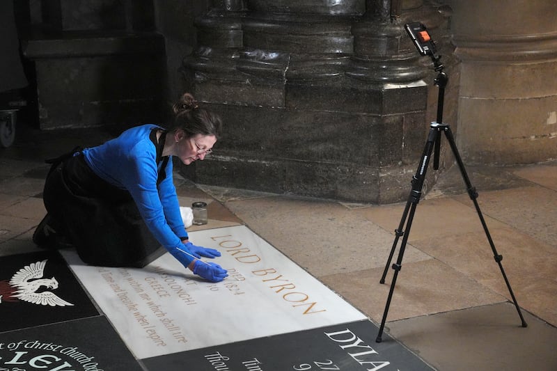 A conservator cleans Lord Byron's memorial stone in Poets' Corner at Westminster Abbey in London, before a service to mark the 200th anniversary of his death. PA