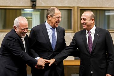Iranian Foreign Minister Mohammad Javad Zarif, left, Russian Foreign Minister Sergei Lavrov, centre, and Turkish Foreign Minister Mevlut Cavusoglu, right, shake hands after consultations on Syria in Geneva. EPA