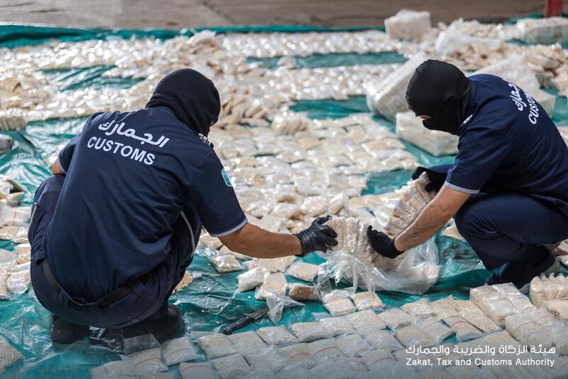 Customs officials unpack the bags of tablets seized.