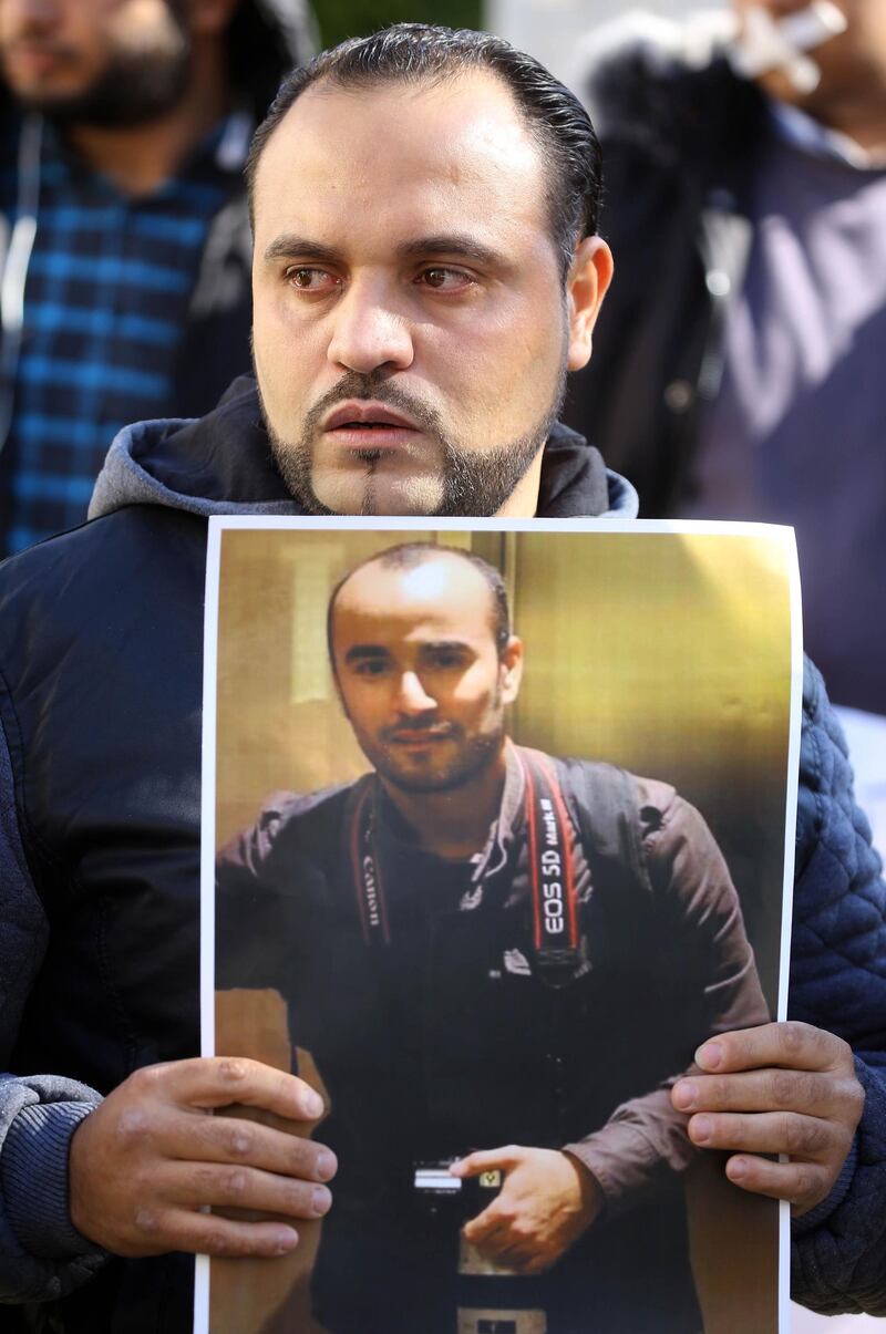 A Libyan journalist holds a portrait of fellow reporter Mohammed bin Khalifa, who was killed the previous day covering militia clashes during a protest to denounce violence against journalists in Tripoli. AFP