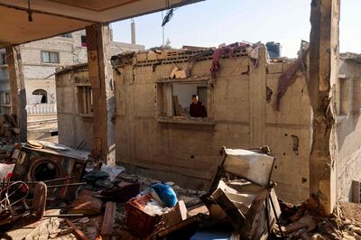 A child looks through the window of a destroyed house in Rafah. AFP