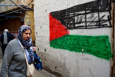 A woman walks next to a Palestinian flag painted on the wall at the Palestinian refugee camp of Mar Elias in Beirut, Lebanon. EPA