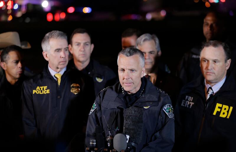 Austin Police Chief Brian Manley, center, stands with other members of law enforcement as he briefs the media, Wednesday, March 21, 2018, in the Austin suburb of Round Rock, Texas. The suspect in a spate of bombing attacks that have terrorized Austin over the past month blew himself up with an explosive device as authorities closed in, the police said early Wednesday. (AP Photo/Eric Gay)