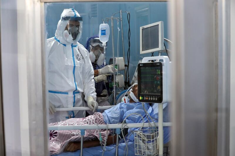 Medical personnel wearing protection suits check a patient at the Ain Shams field hospital in Cairo, Egypt. The field hospital was established in mid-June to receive Covid-19 patients and has a capacity of 200 beds including 11 reserved for critical patients.  EPA