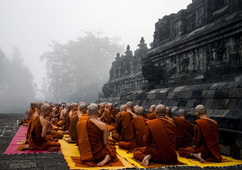 TOPSHOT - Buddhist monks pray on the eve of Buddha's birthday also known as Vesak celebrations, at Borobudur temple in Magelang, Central Java province, on May 18, 2019.  Buddhists are celebrating Vesak, which commemorates the birth of Buddha, his attaining enlightenment and his passing away on the full moon day of May which falls on May 18 this year. / AFP / OKA HAMIED
