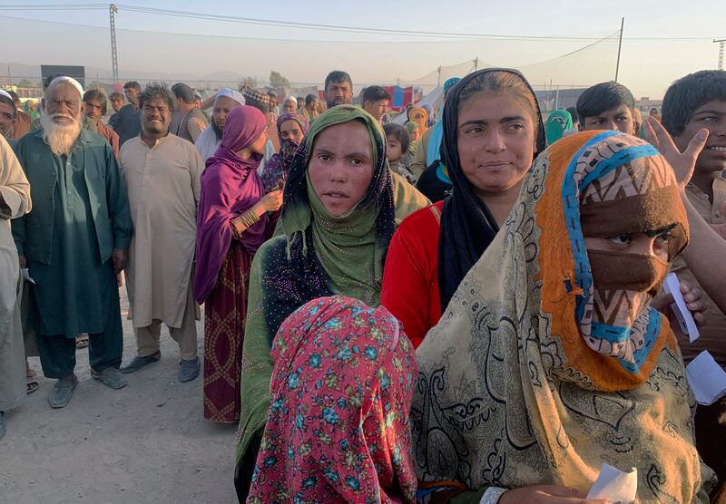 Afghan families gather to receive food on the outskirts of Chaman, a border town in Pakistan's southwestern Baluchistan province.  Dozens of Afghan families have crossed into Pakistan. Photo: AP
