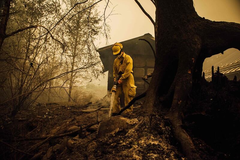 Volunteer firefighter Jacob Ruthrock puts out embers from a fire in Gates, Oregon. AFP