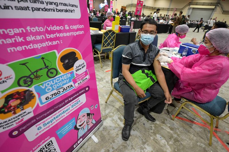 A health worker, right, administers the Sinovac vaccine during a mass vaccination drive against the Covid-19 coronavirus outbreak in Jakarta.