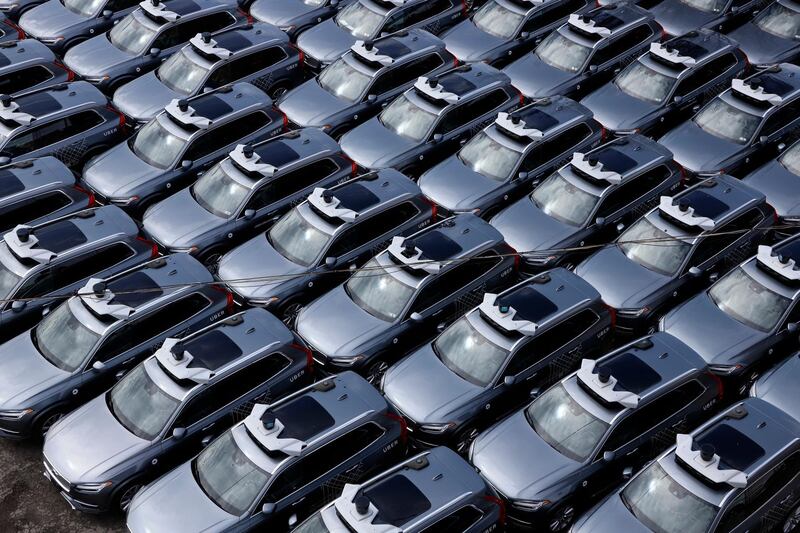 File-This March 20, 2020, file photo shows a parking lot full of Uber self-driving Volvos in Pittsburgh. Uber is selling off its autonomous vehicles development arm to Aurora as the ride-hailing company slims down after its revenues were pummeled by the coronavirus pandemic. Aurora will acquire the employees and technology behind Uber's Advanced Technologies Group in an equity transaction, the companies said Monday. (AP Photo/Gene J. Puskar, File)