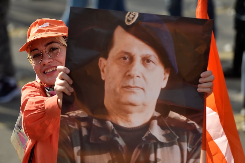 A supporter of the outgoing Lebanese President Michel Aoun holds his portrait during a gathering at Baabda Palace. Mr Aoun served in the Lebanese Army from 1958 to 1991. EPA