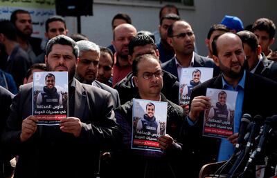 Palestinian journalists carry a portrait of journalist Yasser Murtaja, during his funeral in Gaza City on April 7, 2018.
Among those killed at Friday's protest was Yasser Murtaja, a photographer with the Gaza-based Ain Media agency, who died from his wounds after being shot, the local health ministry said.  
Murtaja's company confirmed his death, with witnesses saying he was close to the front of the protests in Southern Gaza when he was hit. / AFP PHOTO / MAHMUD HAMS