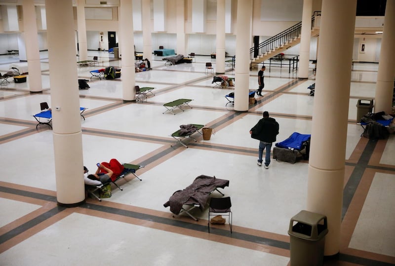 People walk around their living quarters at a temporary men's shelter run by the Downtown Emergency Service Center (DESC) at the Seattle Center Exhibition Hall, currently with 75 beds spaced at least six feet apart, during the coronavirus disease (COVID-19) outbreak in Seattle, Washington, U.S. REUTERS