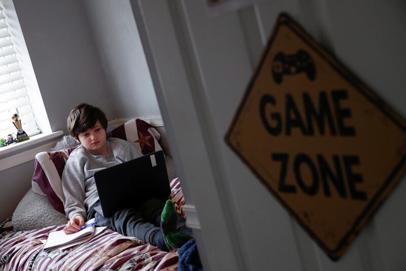 Noah, 10, attends a live lesson on the last day of homeschooling before returning to school, in Hertford. Reuters